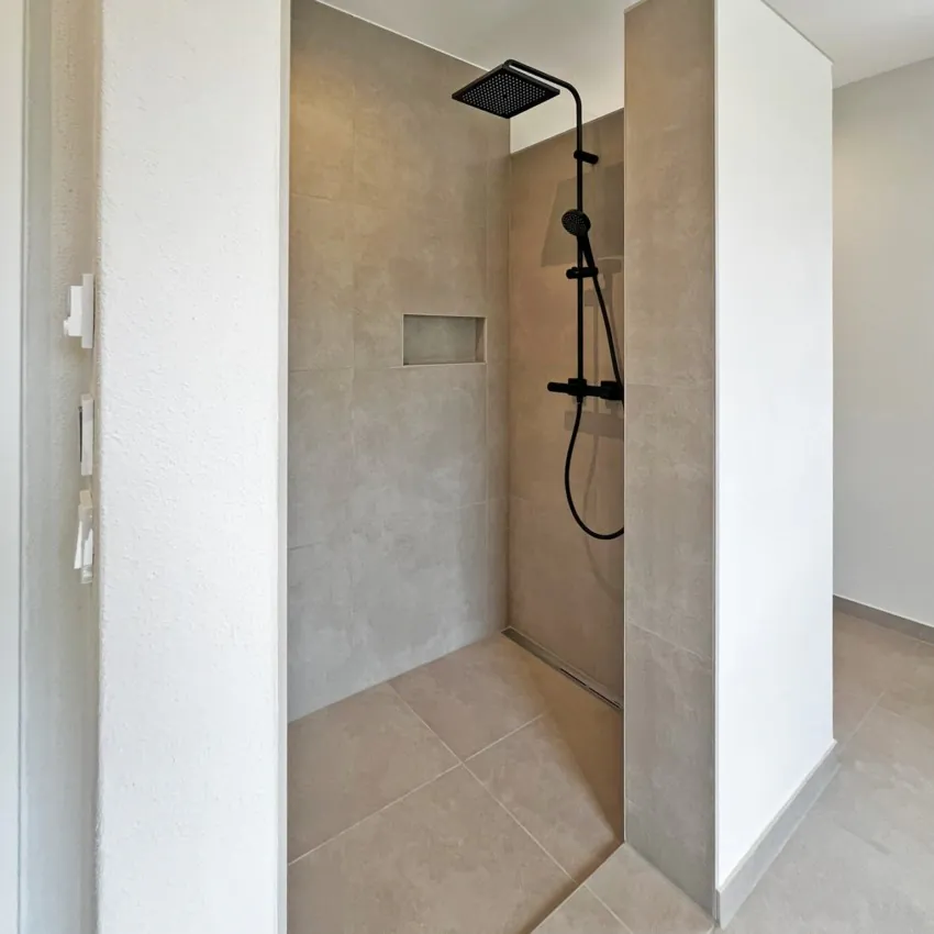 Moderne begehbare Dusche mit Regenduschkopf.