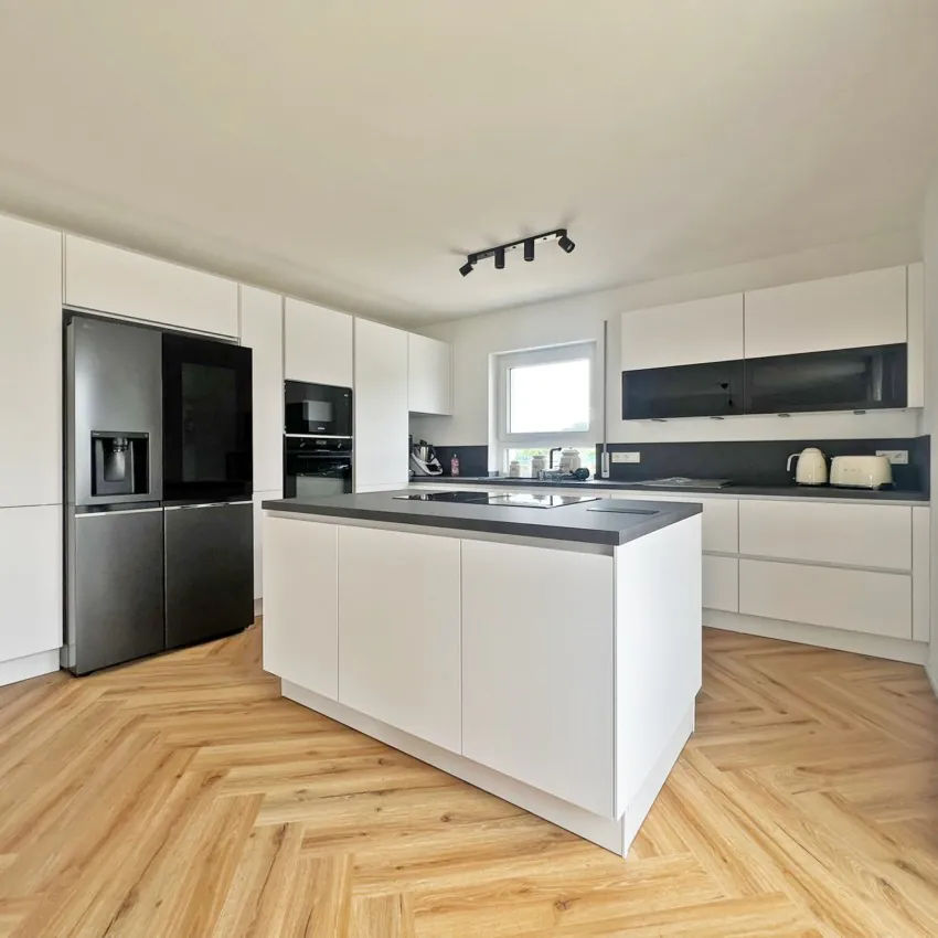 Moderne Küche mit weißen Schränken und Kücheninsel.