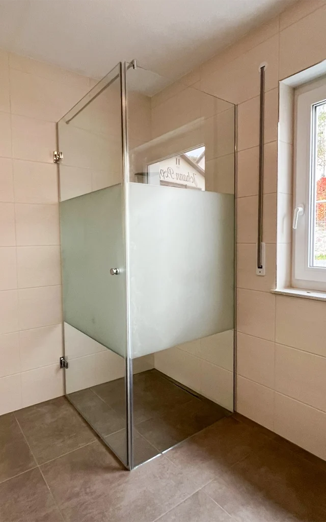Dusche in einem Badezimmer mit Glastür.