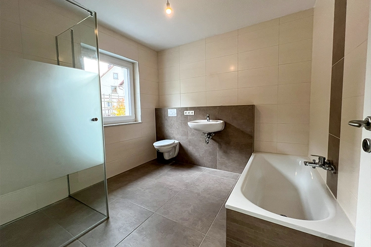 Modernes Badezimmer mit Dusche, Badewanne, Waschbecken und Toilette.