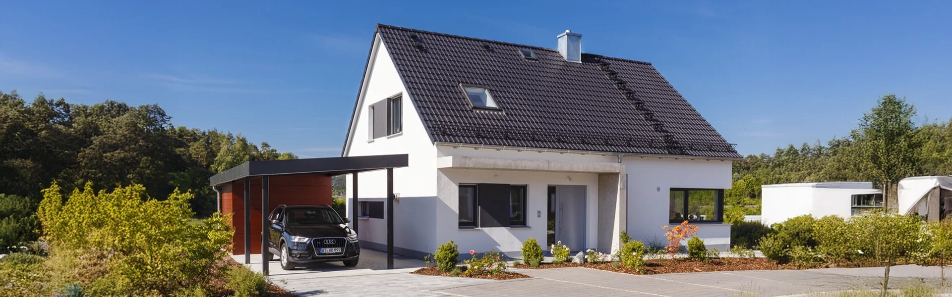 Einfamilienhaus mit Auto im Carport.