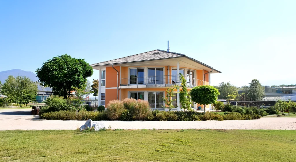 Zweistöckiges, modernes Wohnhaus mit Balkon und Garten.