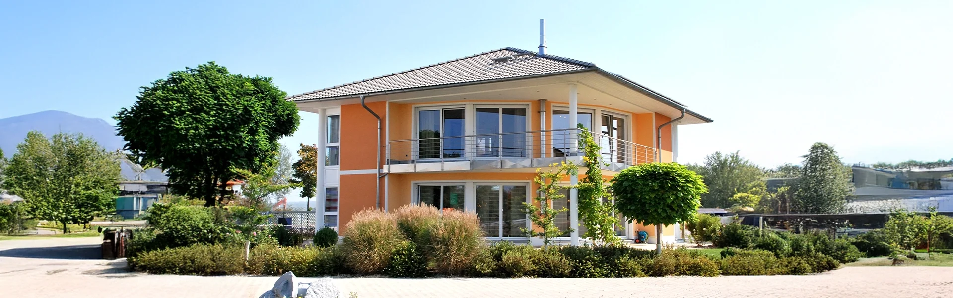 Zweistöckiges, modernes Wohnhaus mit Balkon und Garten.