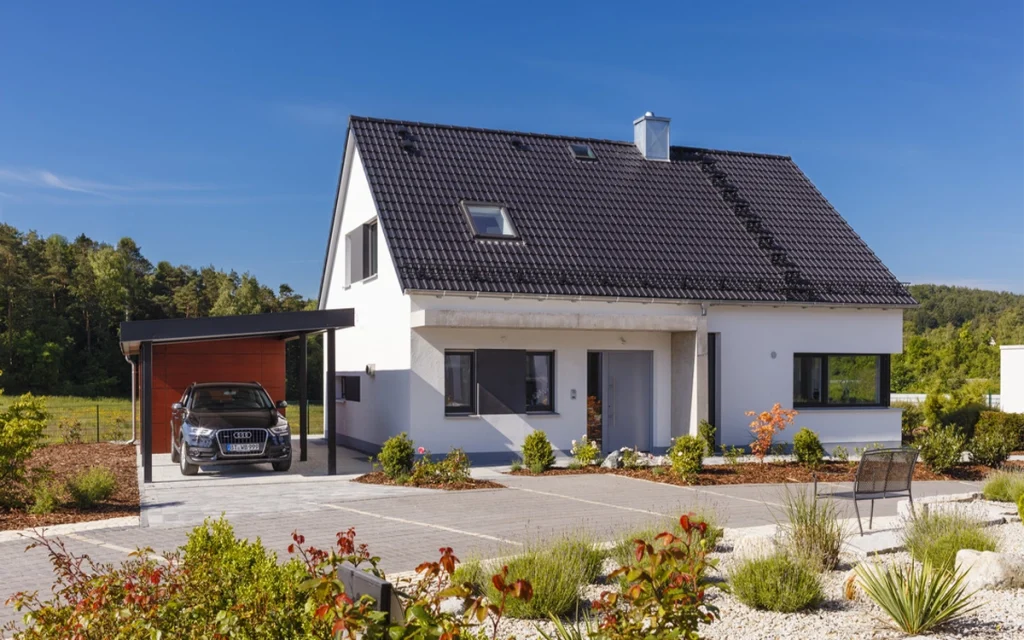 Modernes Einfamilienhaus mit Carport und Garten.