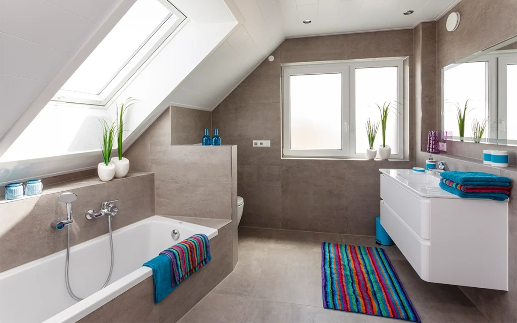 Modernes Badezimmer mit Dachfenster und bunter Dekoration.