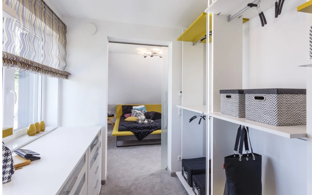 Moderner begehbarer Kleiderschrank mit Blick ins Schlafzimmer.