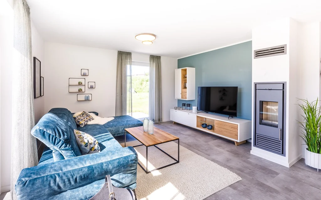 Wohnzimmer mit blauer Couch und Fernseher.