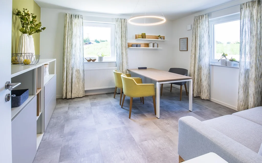 Helles, modern eingerichtetes Esszimmer mit Tisch und Stühlen.