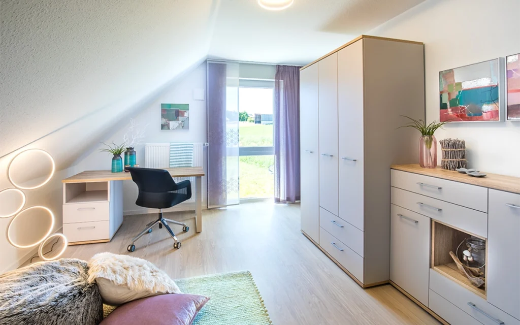 Modern eingerichtetes Zimmer mit Schreibtisch und Schrank.