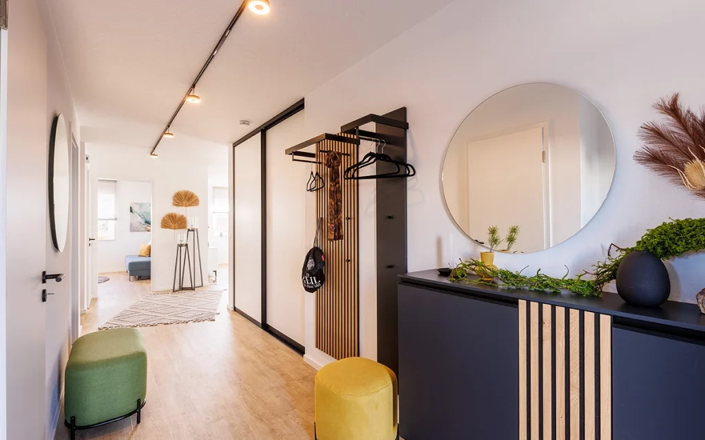 Moderner Flur mit Spiegel, Sitzhocker und Dekoration.