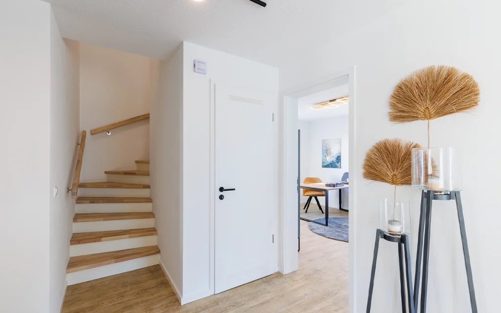 Hausflur mit Treppe und dekorativen Elementen.