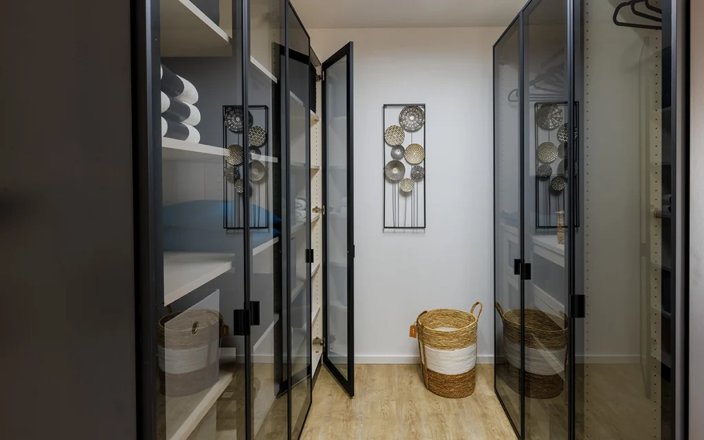 Moderner Schrank mit Glastüren und Körben.