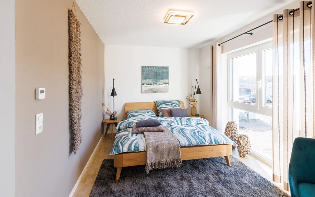 Schlafzimmer mit großem Fenster und Doppelbett.