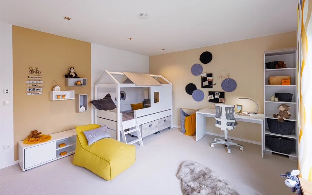 Kinderzimmer mit Hochbett und Schreibtisch.