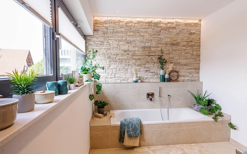 Modernes Badezimmer mit Pflanzen und Steinwand.