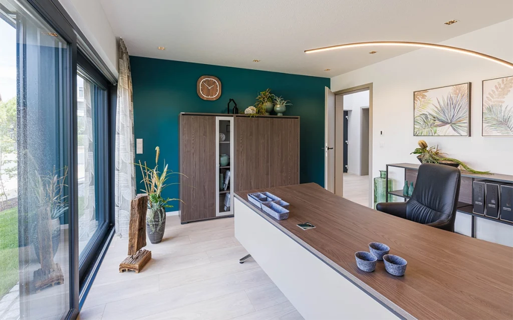 Modern eingerichtetes Büro mit großem Schreibtisch und Pflanzen.