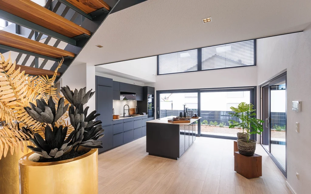 Moderne Küche mit Insel, großem Fenster und Pflanzen.