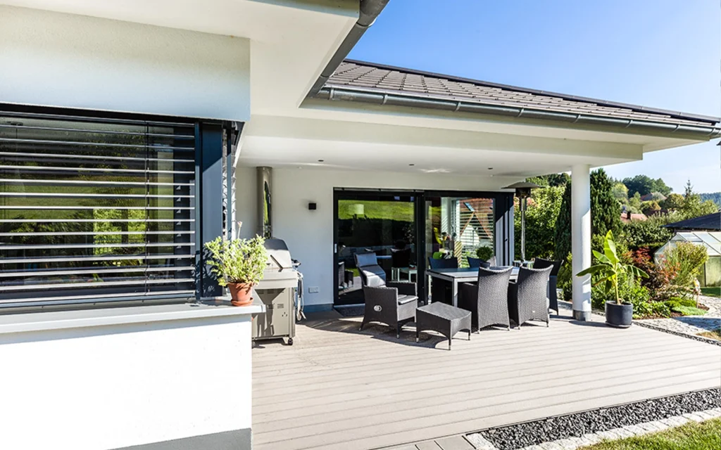 Moderne Terrasse mit Gartenmöbeln und Pflanzen.