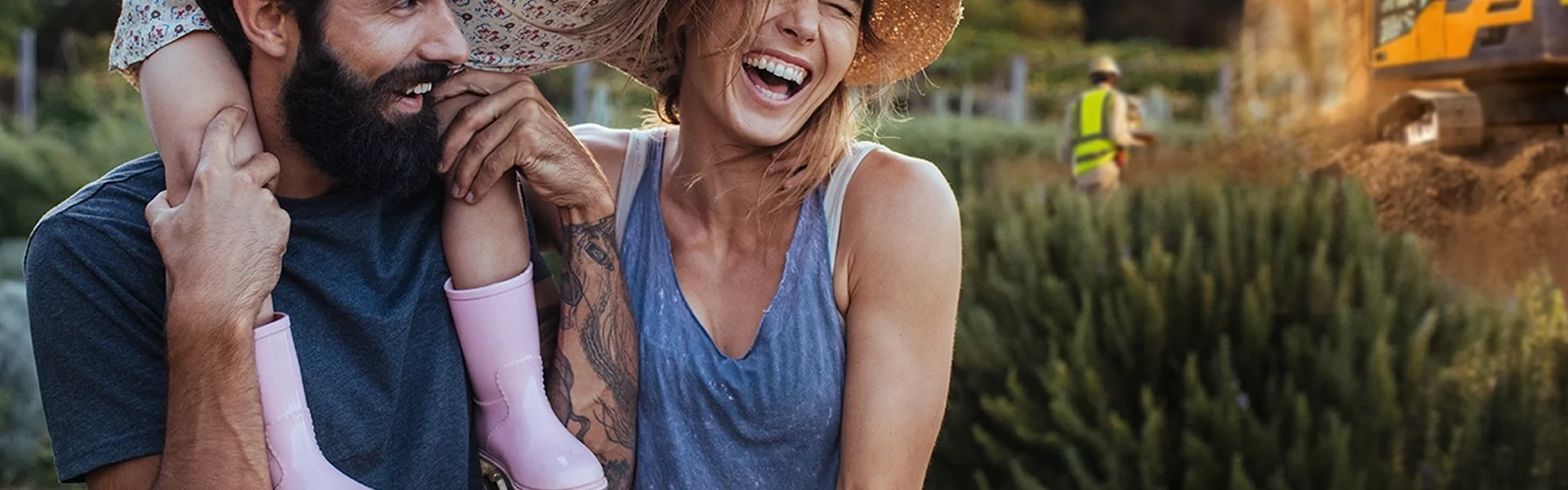 Personen lachen im Freien neben einer Baustelle.