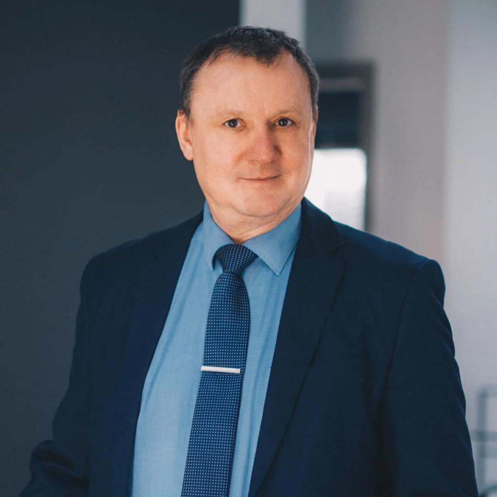 Bauberater Henryk in Anzug und Krawatte.