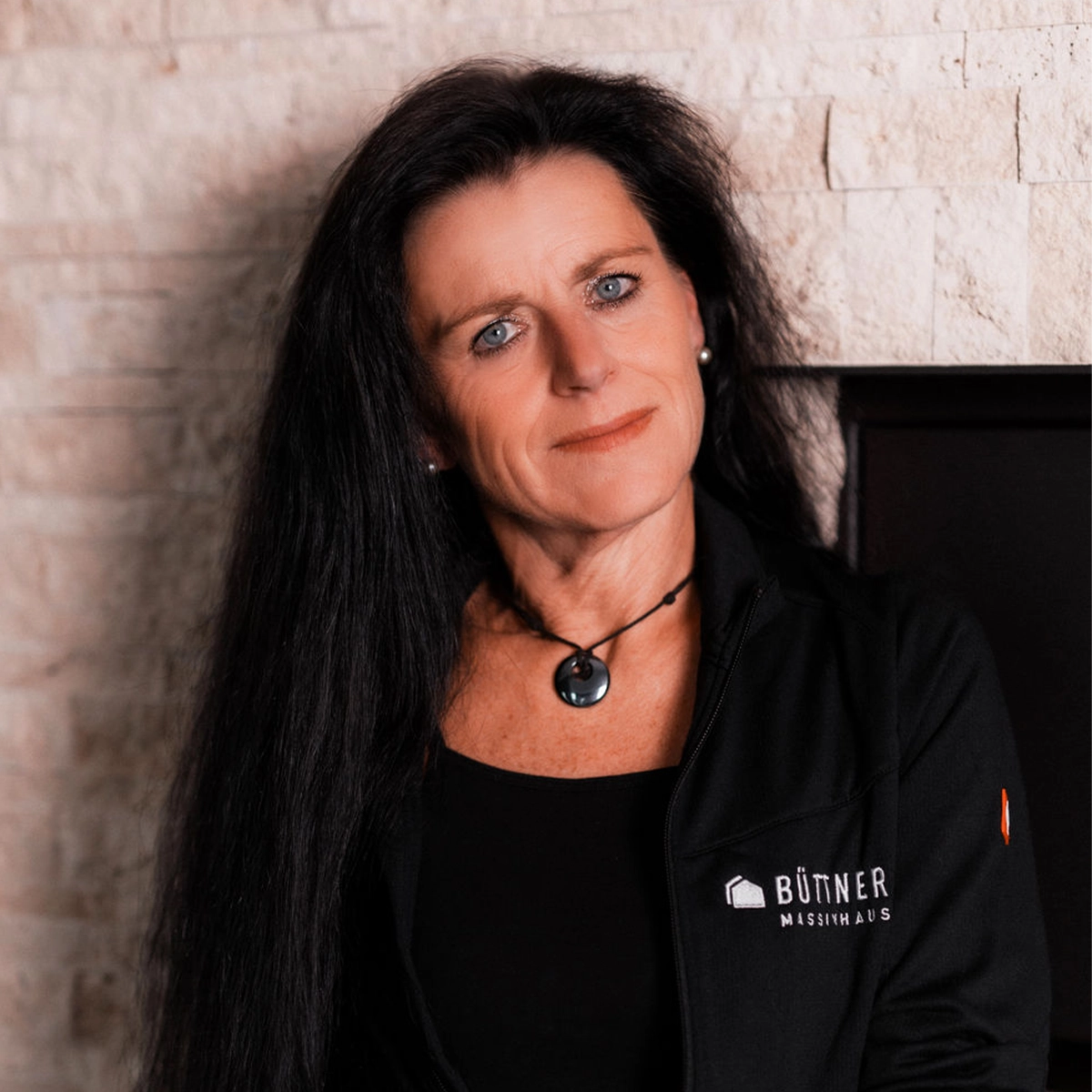 Jessica vor einer Steinmauer.