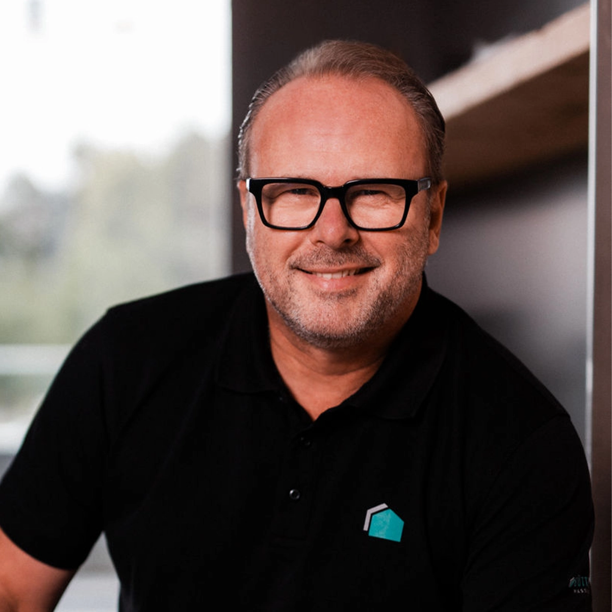 Ralph mit Brille und Bart lächelt in die Kamera.