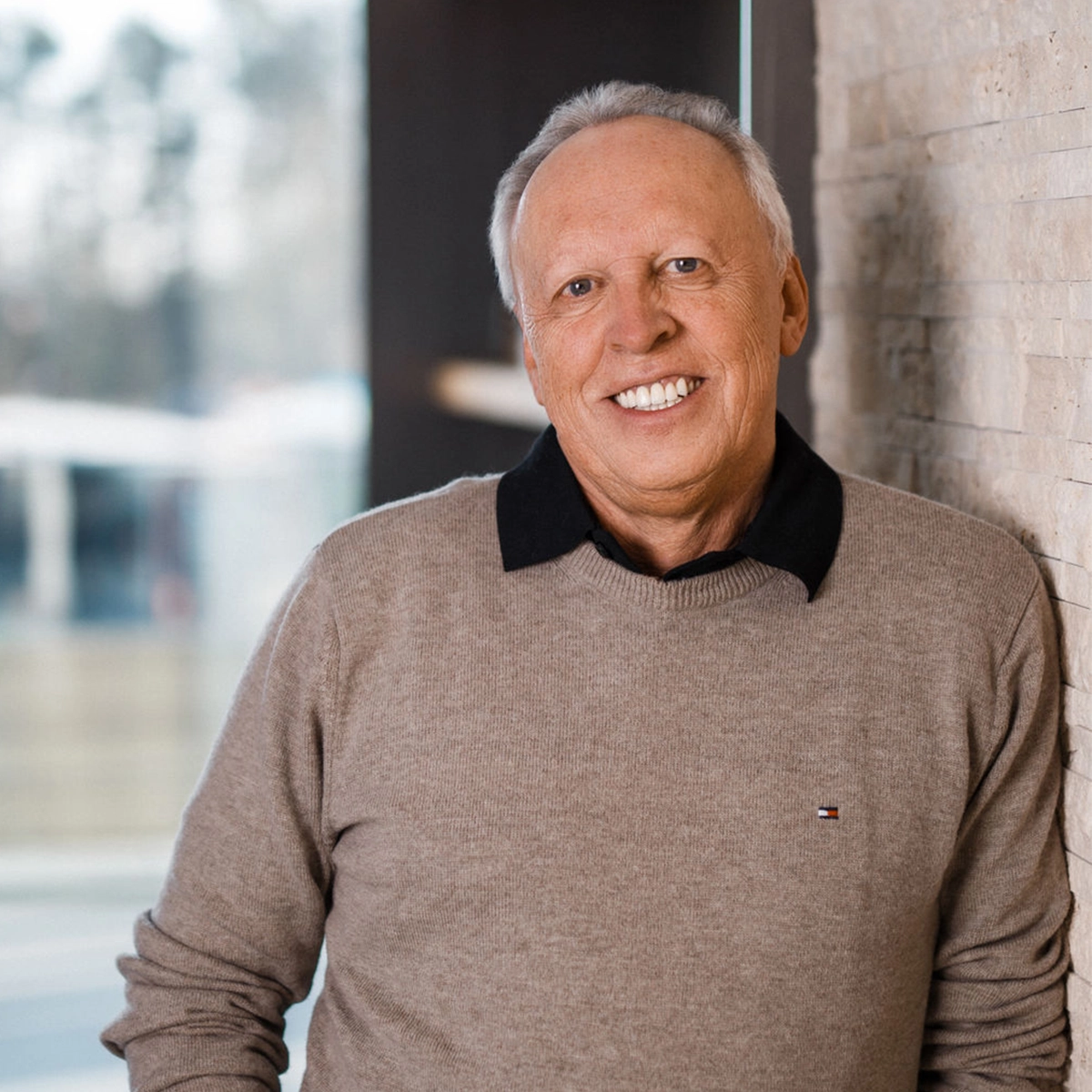 Werner Büttner lächelnd in einem Pullover.