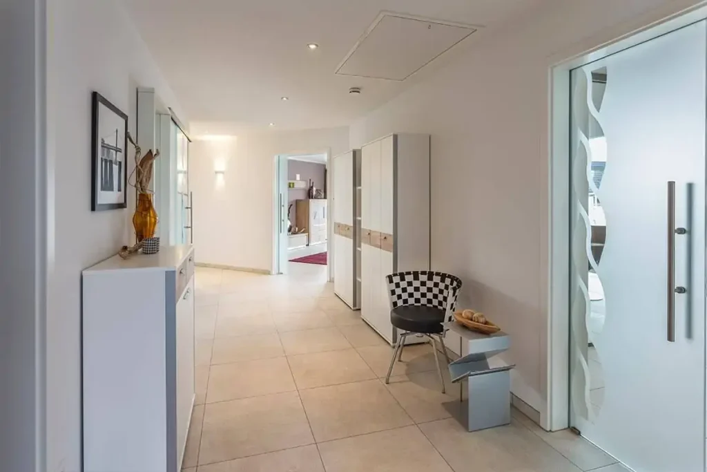 Moderner Flur mit Fliesenboden und Glasdetails.