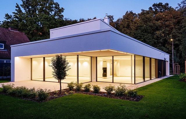 Modernes Haus mit großem Glasfenster und Garten.