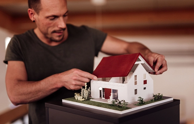 Philipp betrachten ein Architekturmodell eines Hauses.