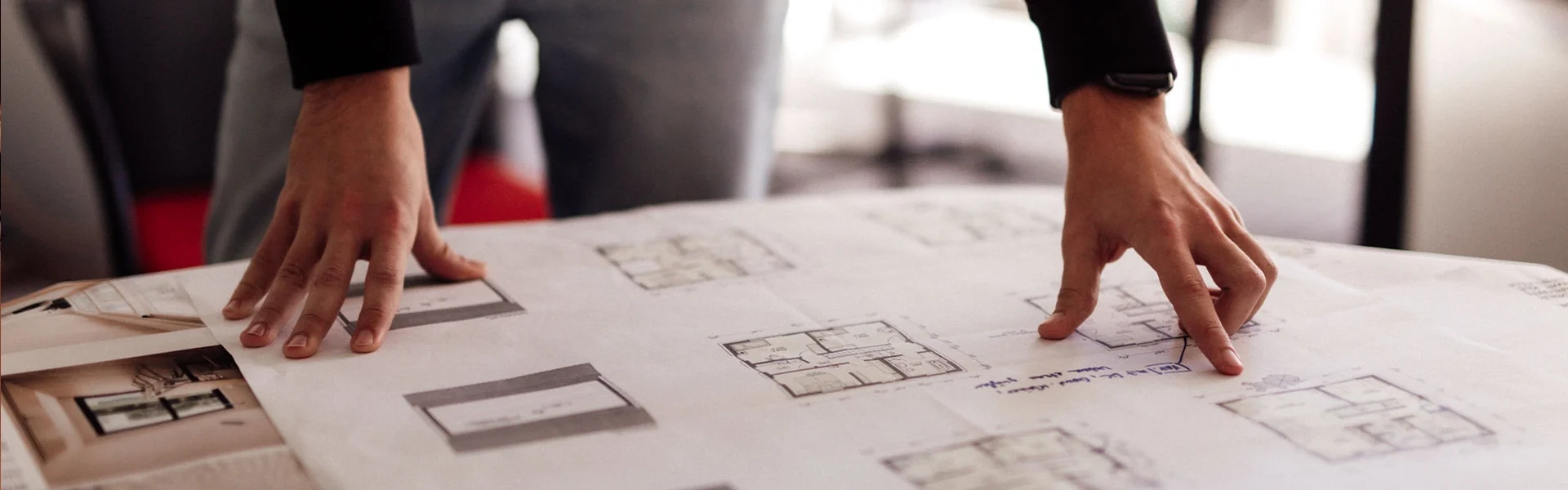 Person betrachtet Baupläne.