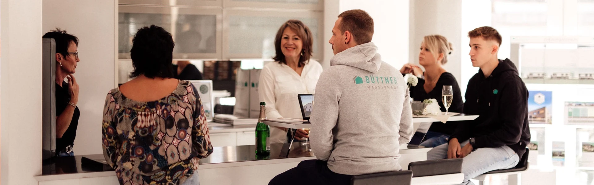 Sechs Mitarbeiter sitzen an einem Tisch und unterhalten sich.