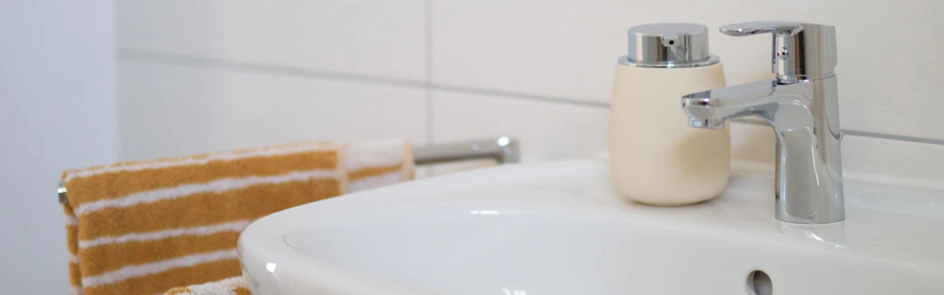 Waschbecken mit Wasserhahn und Seifenspender.