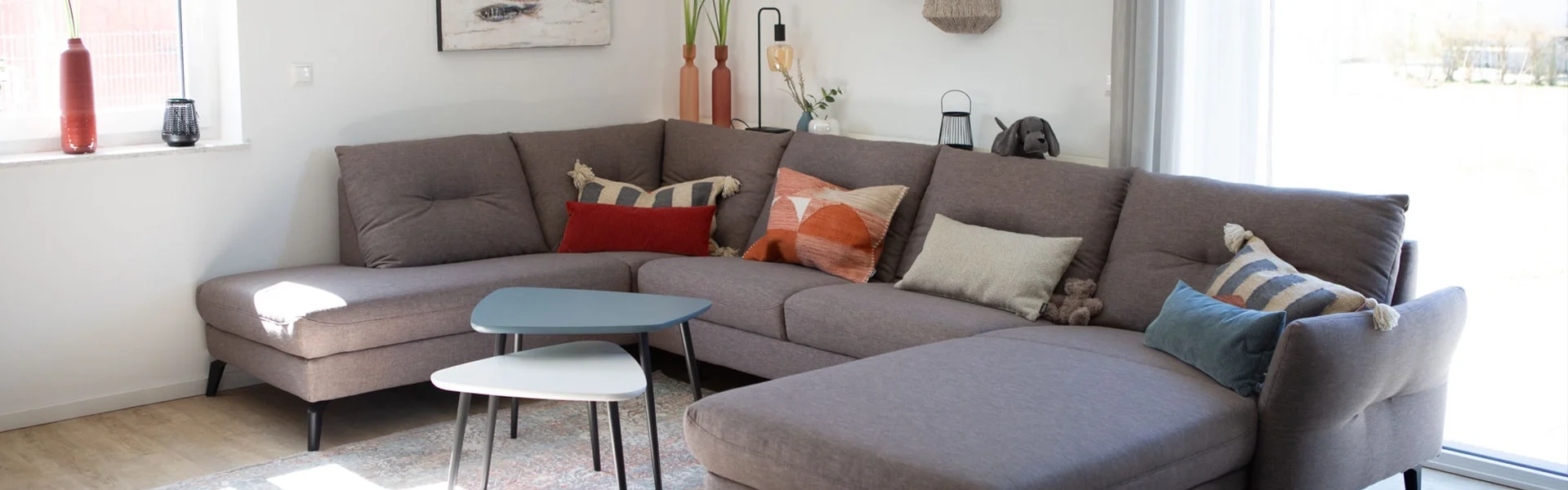 Graues Ecksofa mit Kissen in modernem Wohnzimmer.