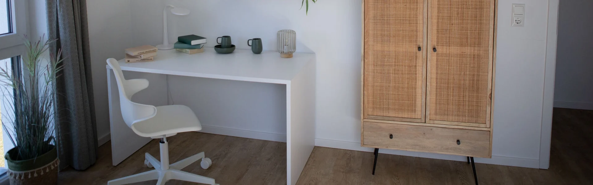 Moderner Arbeitsplatz mit Schreibtisch, Stuhl und Schrank.