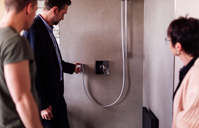 Matthias, Manuela und Philipp begutachten eine Badezimmerarmatur.