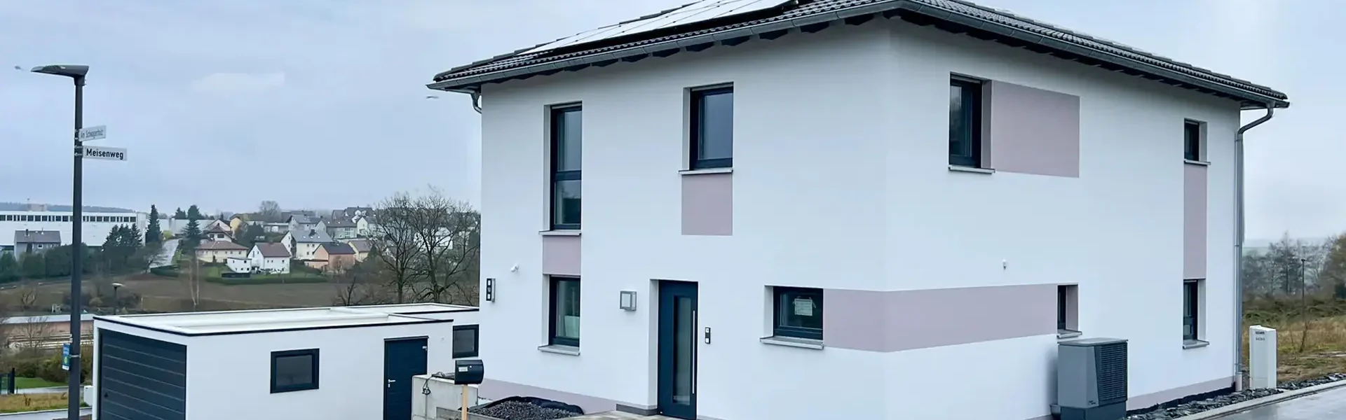 Modernes Einfamilienhaus mit Garage in Wohnsiedlung.