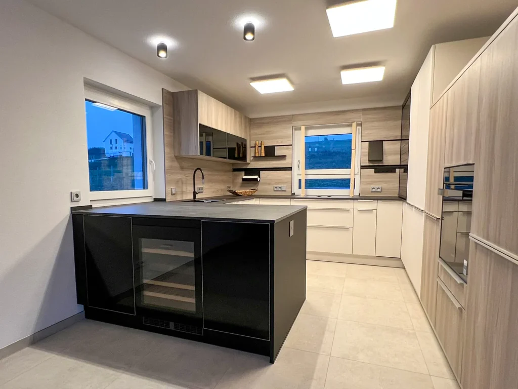 Moderne Küche mit Insel und großen Fenstern.