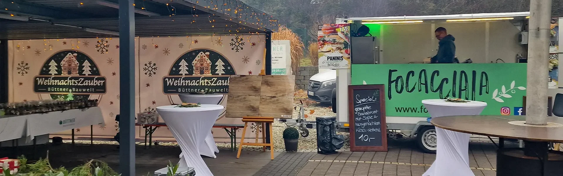 Weihnachtsmarkt mit Essensständen und Dekorationen.