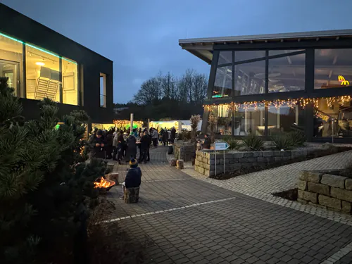 Gebäude mit Dekorationen, Personen versammelt draußen.