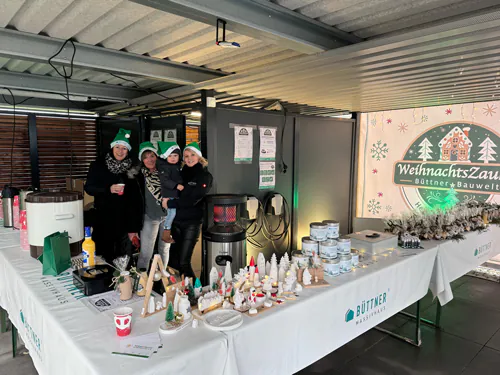 Menschen an einem Weihnachtsstand mit Dekorationen.