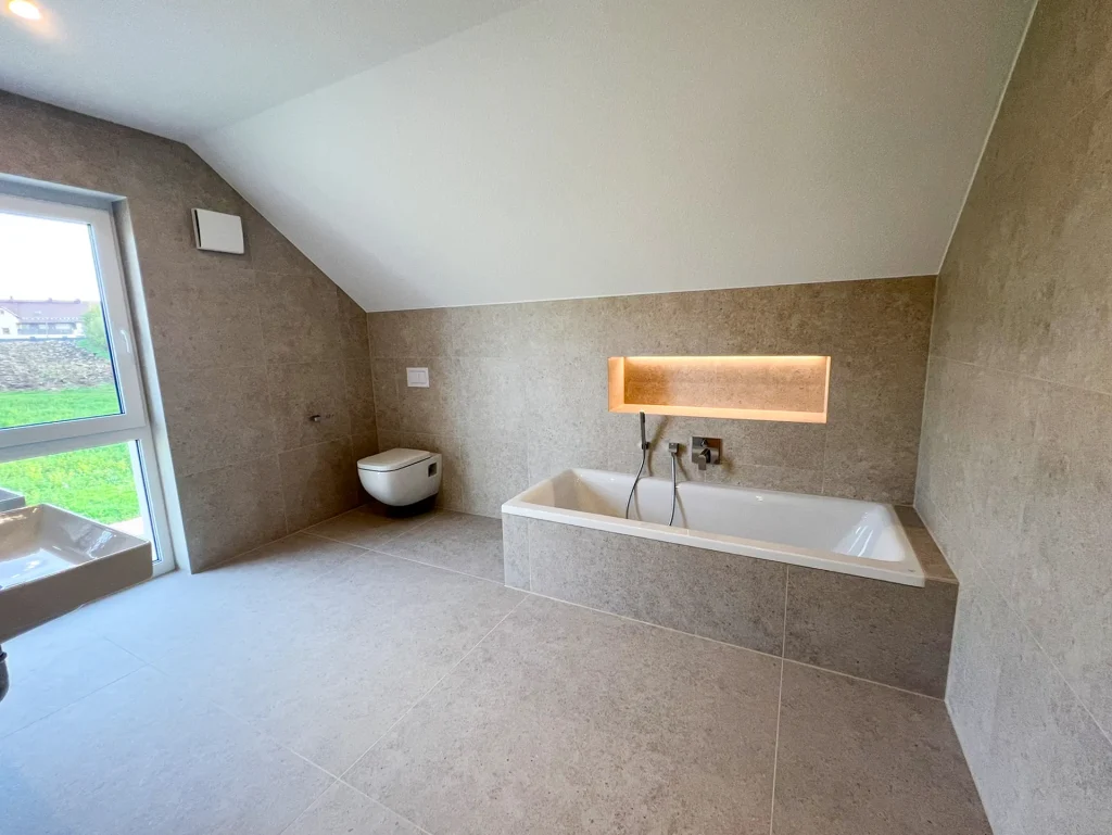 Modernes Badezimmer mit Badewanne und Toilette.