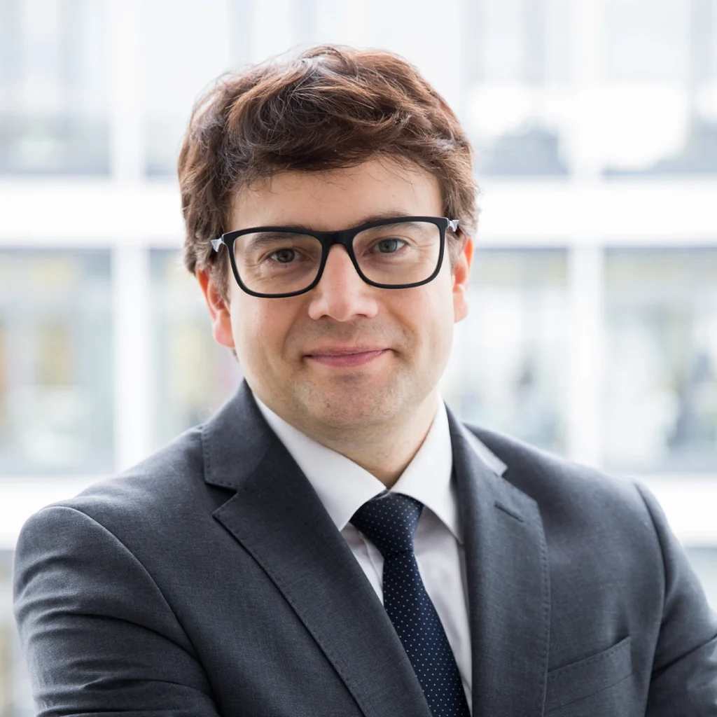 Stefan Nützel in einem Anzug mit Brille.