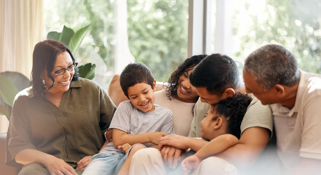 Lachende Personen auf einem Sofa.