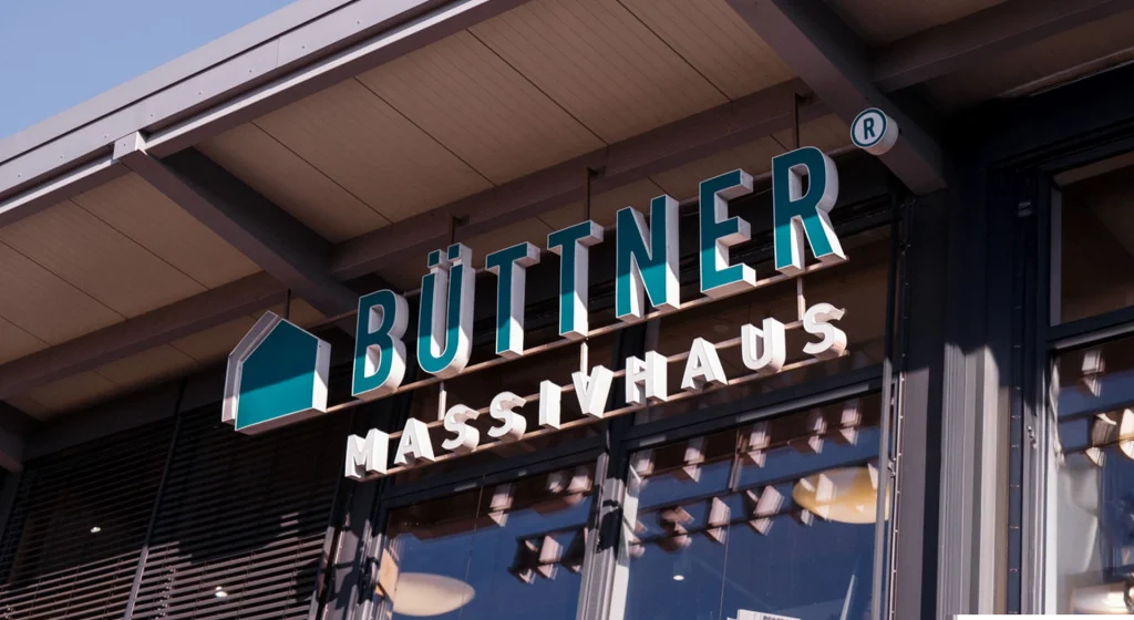Gebäudefront mit Büttner Massivhaus Logo.