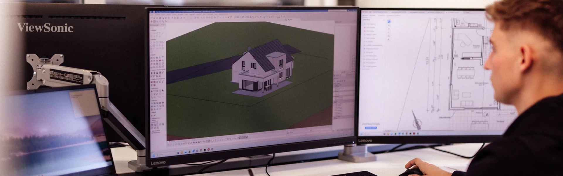 Manuel arbeitet an Computerbildschirmen mit Architektursoftware.