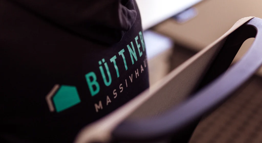 Stuhl und Pullover mit Büttner Firmenlogo.