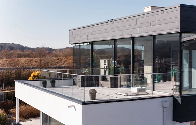 Moderne Terrasse mit Glasgeländer.