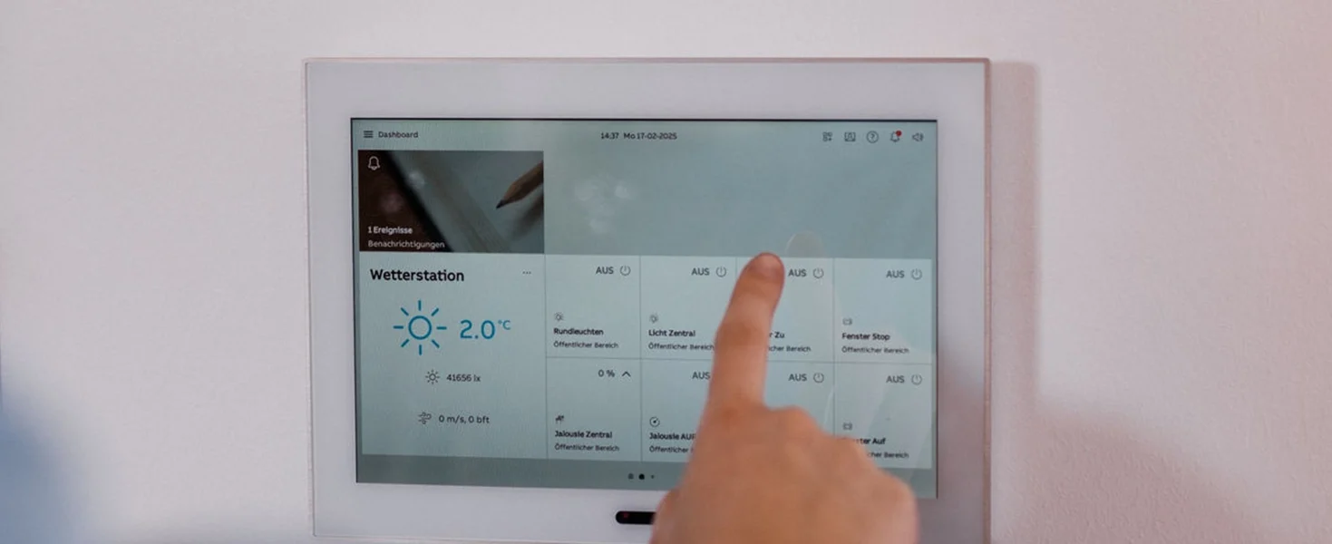 Person verwendet ein Smart-Home-Panel an der Wand.