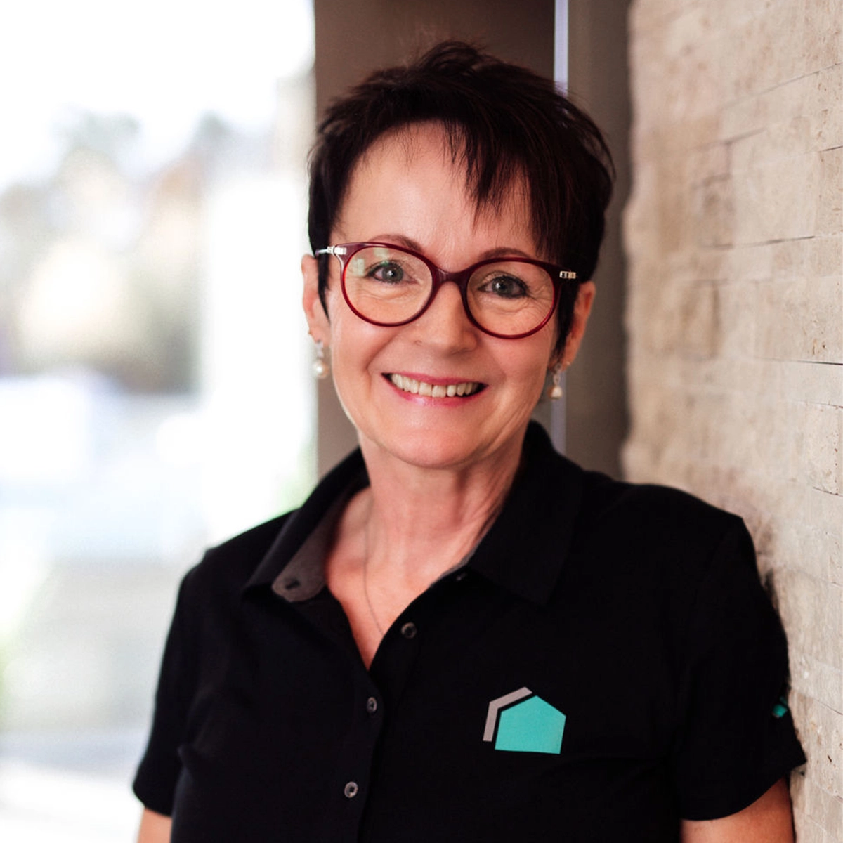 Manuela mit Brille lächelt.